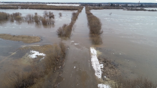 Через дорогу в Коромыслово переливается вода.